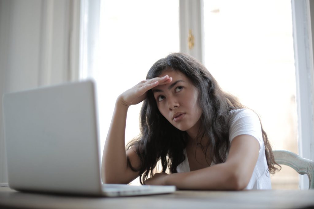 young annoyed female freelancer using laptop at home