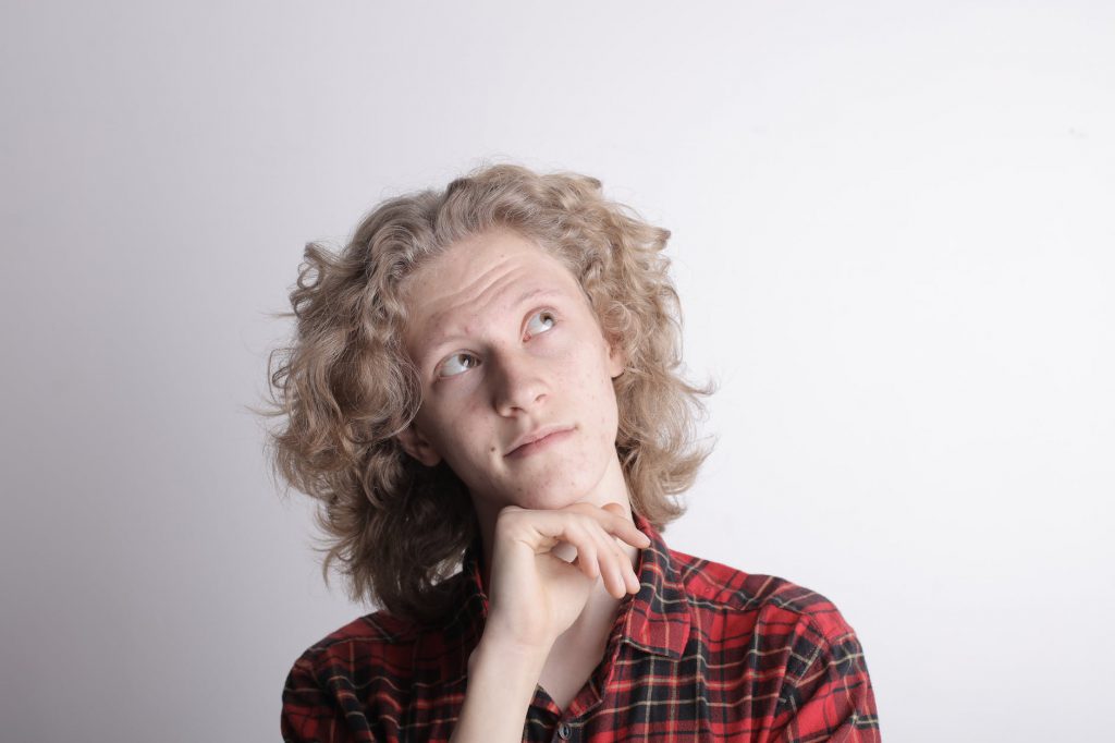 pensive male teen on gray background